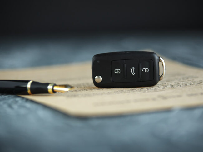 Autoschlüssel auf Vertrag mit geöffnetem Füller - Bildlich für Autokreditvertrag